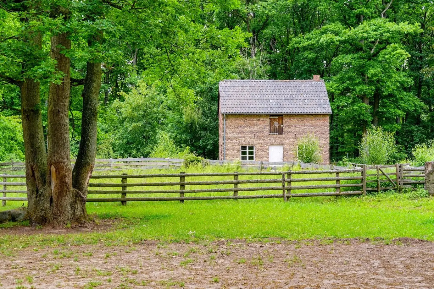 Backsteinhaus zwischen grünen Bäumen im Freilichtmuseum im Dorf Kommern in der Eifelregion in Deutschland.